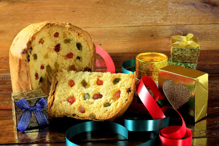 slice of Panettone closeup with candied fruits wooden table. Christmas decoration. front viewの写真素材