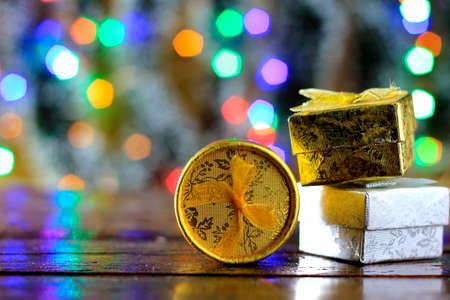 gift boxes on wooden table, christmas decoration, blurred lights on the background