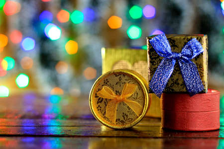 gift boxes on wooden table, christmas decoration, blurred lights on the background