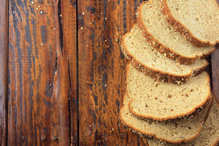 Wholegrain sliced organic bread composed of oats and flax seeds on wooden table. Copy space.Top view
