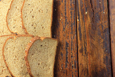 Wholegrain sliced organic bread composed of oats and flax seeds on wooden table. Copy space.Top view