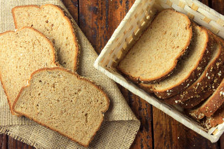 Organic sliced wholemeal bread, made from oats and flax seeds inside basket. Healthy diet. Top View