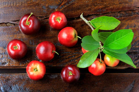 Acerola Cherry raw, fresh, on rustic wooden table, High vitamin C and antioxidant fruits. Top view.