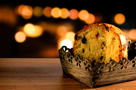 closeup panettone inside box on wooden table, bokeh background with lights, front viewの写真素材