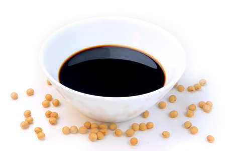 Soya beans with dark soy sauce in a ceramic bowl isolated over white backgroundの写真素材