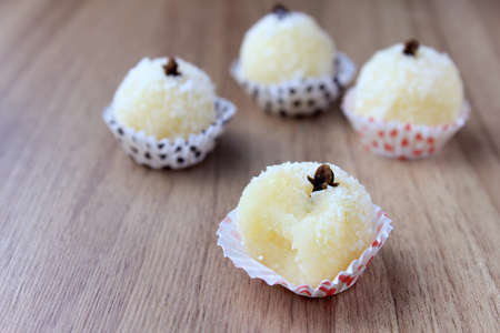 coconut kiss (beijinho de coco) - typical sweet Brazilian cuisine isolated on wooden background. Closeup photographyの写真素材