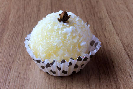 coconut kiss (beijinho de coco) - typical sweet Brazilian cuisine isolated on wooden background. Closeup photographyの写真素材