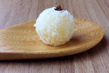 coconut kiss (beijinho de coco) - typical sweet Brazilian cuisine isolated on wooden background. Closeup photographyの写真素材