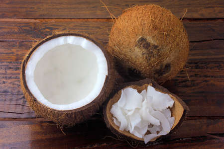 fresh coconut flakes and chips placed in bark and shell isolated on rustic wooden backgroundの写真素材