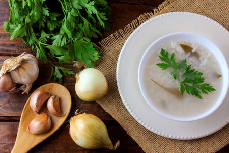 congee in ceramic bowl on rustic wooden table, traditional rice porridge typical of Asian cuisine. Top viewの写真素材