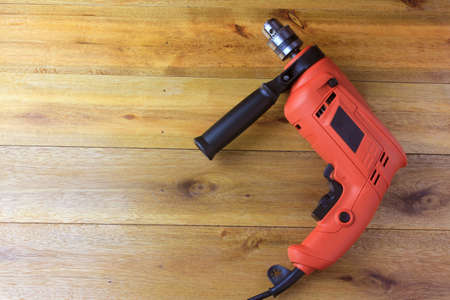 electric drill on carpenter's wood table used in construction and furniture design and repair. Equipment isolated on wooden backgroundの写真素材