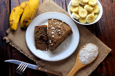 Healthy homemade banana cake and raisins made with oatmeal on rustic wooden table. sugar-free, milk-free, gluten-freeの写真素材