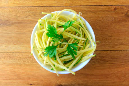 Homemade raw zucchini pasta in ceramic bowl on rustic wooden table. concept of healthy food. Top viewの写真素材