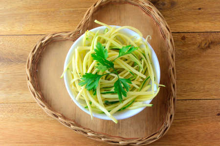 Homemade raw zucchini pasta in ceramic bowl on rustic wooden table. concept of healthy food. Top viewの写真素材