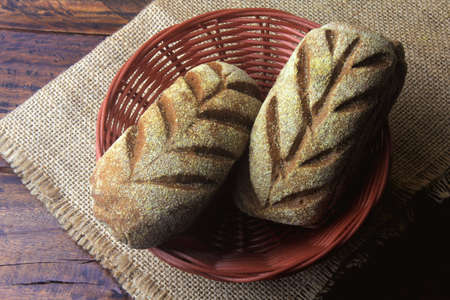Australian bread loaf in basket over rustic wooden background. Traditionally this bread is made with chocolate powder, brown sugar and honey. Top viewの写真素材
