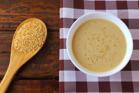Tahini in ceramic bowl on rustic wooden table- cream or paste made from sesame seeds (sesame) widely used in Middle Eastern cuisine. Top viewの写真素材