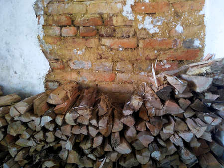Firewood stack for winter to feed fireplace, with rustic wall background. Copy Spaceの写真素材