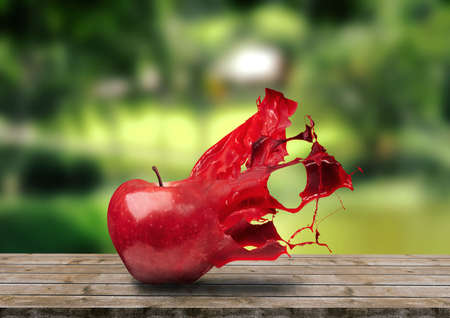 apple crumbling in splash on rustic wooden table. front viewの写真素材