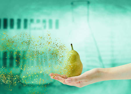Hand holding fruit pear in disintegration on laboratory background. front viewの写真素材
