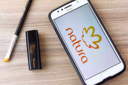 Rio de Janeiro, Brazil - February 14, 2020: Natura logo on the smartphone screen, on wooden table....