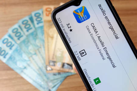 Rio de Janeiro, Brazil - September 5, 2020: Emergency Aid Logo on the smartphone screen. Financial aid given by the Brazilian Federal Government to informal workers because of Covid-19のeditorial素材