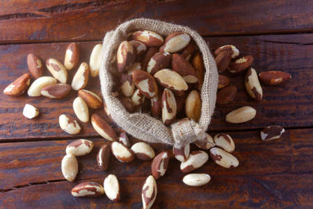 Chestnuts from Para or Brazil nuts, in Portuguese: Castanha-do-ParÃ¡ or Castanha-do-Brasil, in the bag on a rustic wooden table. Top viewの写真素材