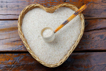 portion of raw psyllium husk in basket over rustic wooden table. top viewの写真素材