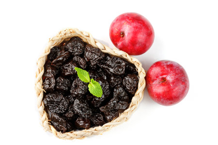 Dried plum in basket isolated on a white background top view. Dehydrated fruitsの写真素材