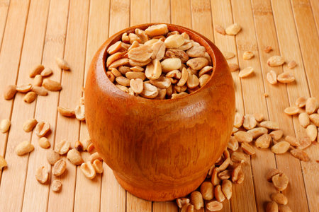 Roasted peeled peanuts in wooden bowl on table. Close up view