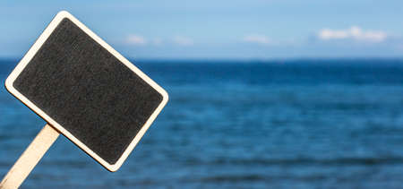 Blank board sign on blue sea water surface