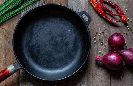 pan on wooden table with vegetablesの写真素材