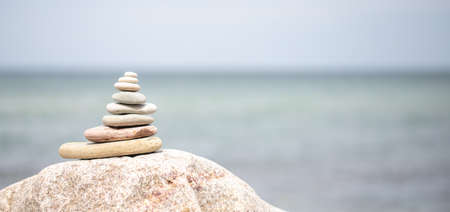 stack of stones on beach with sun light