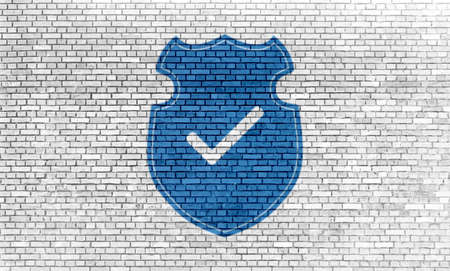 blue colored shield security icon on grunge brick wall backgroundの写真素材