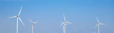 wind turbine in the wind with blue sky in background under sun light