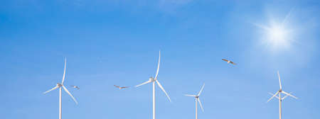wind turbine in the wind with blue sky in background under sun light