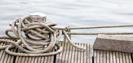 bollar on pier with blue sea water in background