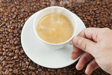Cup of coffee sitting in a bed of coffee beans