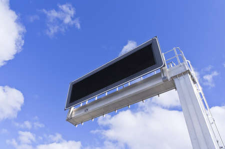 Electronic advertising panel against a background of blue sky with clouds