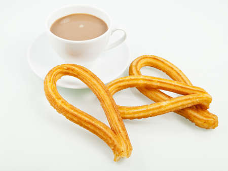 Typical spanish churros with a cup of coffee. Churros is a sweet fried pastry for breakfast.の写真素材