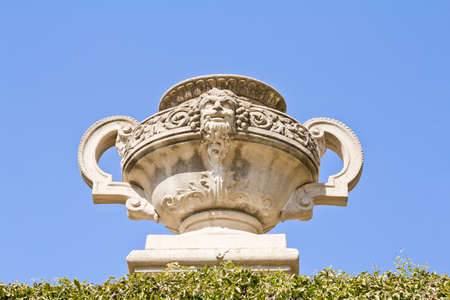 Picture of a marble vase with a human face Greek style  Decorative architecture in a public park の写真素材