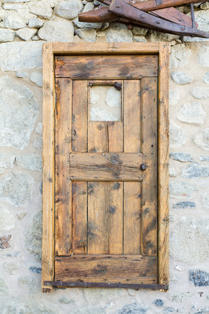 Outdoor shot of an antique door hanging on the wall.の写真素材