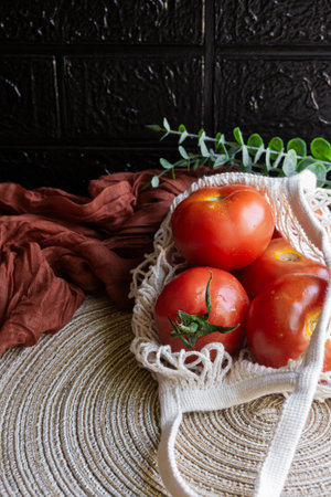 Fresh tomatoes inside a sustainable shopping bag made of natural twine.の写真素材