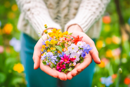 Crop shot of a girl in casual clothes holding wildflowers. Springtime concept. Horizontal.の素材