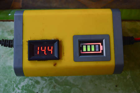 Close-up of a high voltage power meter on a green background
