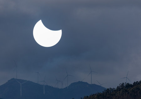 Wind turbines in the mountains at dawn with the moon in the skyの写真素材