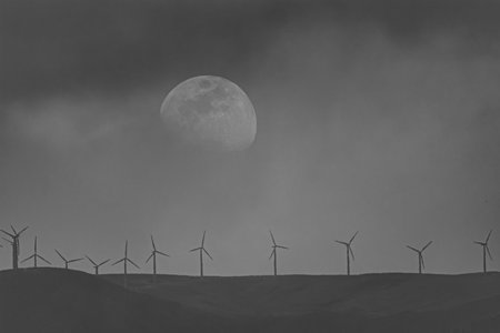 Wind turbines in front of the full moon, black and white imageの写真素材