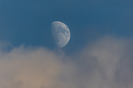 Moon in the blue sky with clouds, closeup of photo.の写真素材