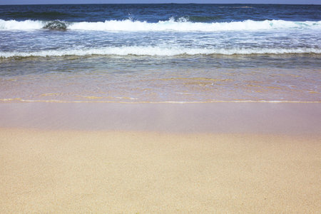 Beautiful sandy beach and waves of the sea on a sunny day