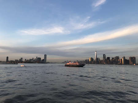 A sunset cruise to Ellis Island an Statue of Liberty. You can see the sun setting down and returns with all the lights shinning in New York City. Amazing landscape.の写真素材