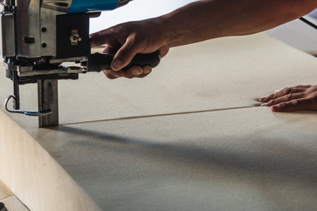 a man cutting a piece of foam rubberの写真素材